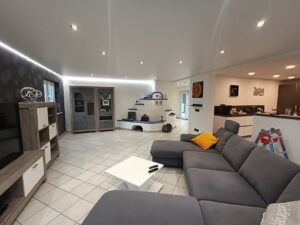 Matte Spanndecke im Wohnzimmer mit indirekter LED-Hintergrundbeleuchtung und integrierten LED-Spots – moderne Deckengestaltung von TopDecken in Wiesbaden, Frankfurt & deutschlandweit