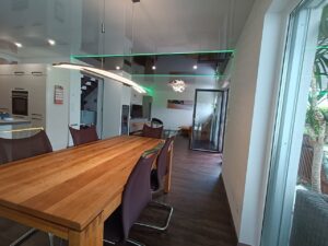 Glänzende Spanndecke im Wohnzimmer mit moderner LED-Lichtlinie – Hochglanz-Design von TopDecken in Wiesbaden, Frankfurt & deutschlandweit