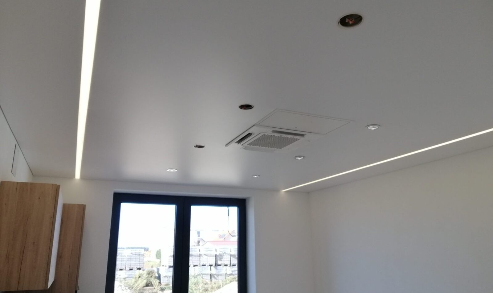 Akustik-Spanndecke im Büro mit LED-Lichtlinien, Spots und integrierter Deckentechnik