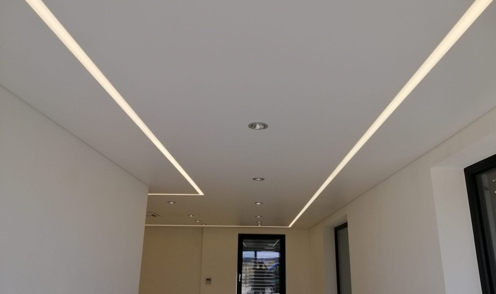 Fertige Akustik-Spanndecke mit integrierten LED-Lichtlinien in einem modernen Raum