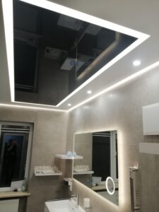 Schwarze Glanz-Spanndecke kombiniert mit weißer matter Spanndecke und moderner LED-Lichtlinie im Badezimmer – exklusive Deckengestaltung von TopDecken in Wiesbaden, Frankfurt & deutschlandweit