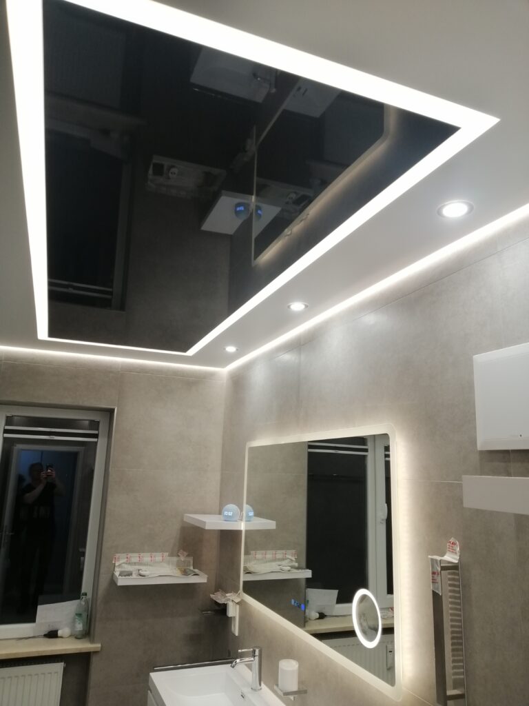 Schwarze Glanz-Spanndecke kombiniert mit weißer matter Spanndecke und moderner LED-Lichtlinie im Badezimmer – exklusive Deckengestaltung von TopDecken in Wiesbaden, Frankfurt & deutschlandweit