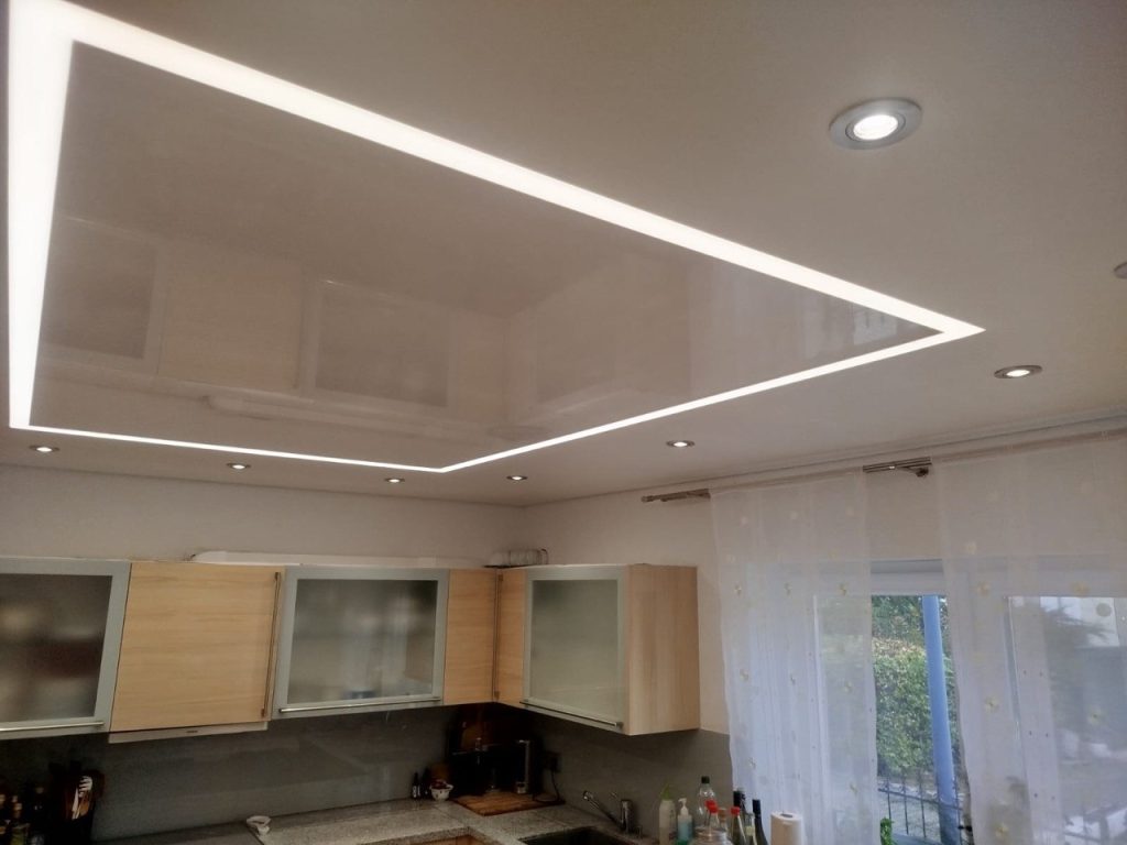 Moderne Küche mit Lackspanndecke, LED-Lichtlinie und integrierten Spots