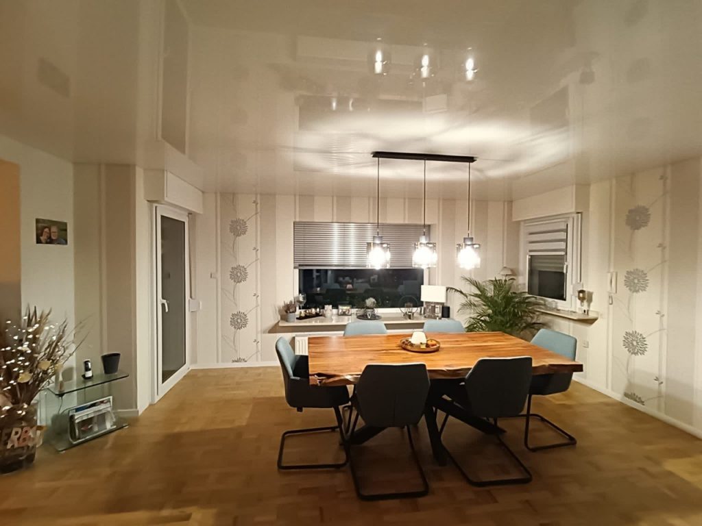Moderner Essbereich mit weißer Hochglanz-Spanndecke und LED-Pendelleuchten